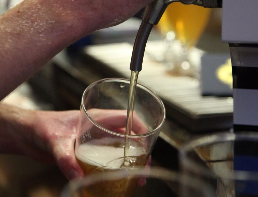 Barman Pouring Tasy Craft Beer at Independent Craft Brewery